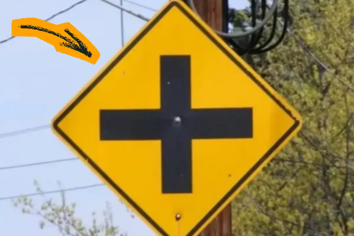 Placa amarela com cruz preta alerta para cruzamento à frente
